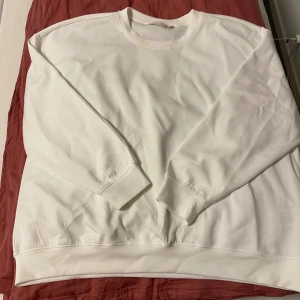Vit sweatshirt från 157 - Säljer en stilren vit sweatshirt från 157 i storlek XL. Tröjan har rund halsringning, långa ärmar och ribbade muddar vid ärmslut och nederkant. Perfekt för en clean och avslappnad look. Oversized