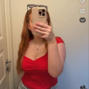 Röd linnetopp med rynk framtill - Säljer en snygg röd linnetopp med rynkdetalj framtill och smala axelband. Toppen har en v-ringad skärning och är perfekt för varma dagar. Enkel och stilren design som är lätt att matcha med jeans eller kjol🩷