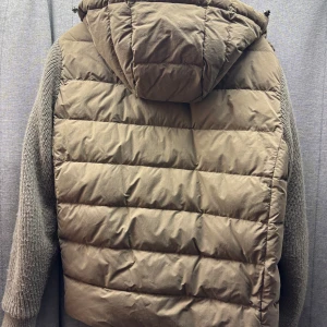 Massimo dutti cardigan - Säljer en beige pufferjacka från Massimo dutti med stickade ärmar och huva. Jackan har quiltad kropp, dragkedja framtill och ribbade muddar. Perfekt för dig som vill ha en chill och snygg look under höst och vinter.