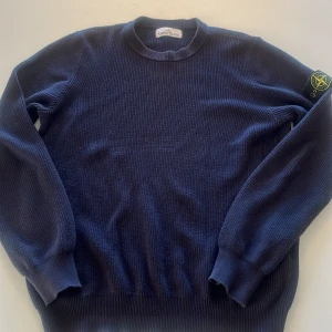 Mörkblå stickad tröja Stone Island - Säljer en mörkblå stickad tröja från Stone Island med klassisk rund hals och ikonisk patch på vänster ärm. Tröjan har ribbade muddar och är tillverkad i ett grovstickat material som ger en clean och stilren look. Perfekt inför höst/vinter storlek S funkar även som M. Ny pris 4000 mitt pris 750. Priset kan diskuteras vi snabb affär