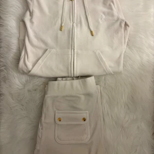 Vita mjukisbyxor från Juicy Couture S - Supermjuka vit/beige sett från Juicy Couture i storlek S. Byxorna har resår i midjan, en ficka med guldknappar bak och är tillverkade i ett skönt fleecematerial. Koftan har också gulddetaljer super snygg!!!