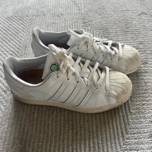 Adidas Superstar vita sneakers - Säljer ett par klassiska Adidas Superstar sneakers i vitt skinn från junkyard☺️