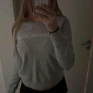 Grå Calvin Klein Jeans sweatshirt - Säljer en stilren grå sweatshirt från Calvin Klein Jeans med vit logga över bröstet. Skriv privat om ni har några frågor.