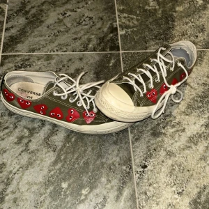 Converse skor - Säljer ett par gröna Converse med unika röda hjärtan längs sidan. Skorna har klassisk snörning och en vit sula. Perfekta för dig som vill ha en cool och avslappnad stil. Tveka inte på att kontakta mig vid minsta fundering. Ord pris ca 1000kr mot pris 350