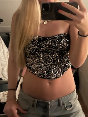 Glittrig svart paljettkorsett - Säljer en svart korsettopp täckt med glittriga paljetter. Perfekt till nyår!!Toppen har dragkedja baktill💕💕💕den är från berska