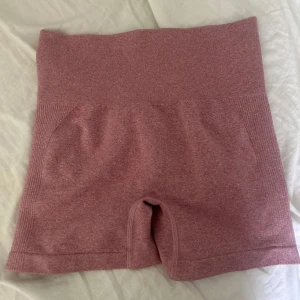 Rosa seamless träningsshorts - Snygga rosa seamless shorts med hög midja och scrunch-detalj bak. Stretchigt material som sitter tight och bekvämt, perfekta för gymmet eller andra träningspass. Ribbad midja och sidor för extra support och stil.