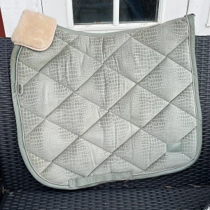 Eskadron dressyr schabrak💚 - Ett grönt fint Eskadron schabrak i storlek cob💚 Med fluf som kan tas bort🤗 HELT NYTT och aldrig använt bara tästas🥰 Orginal pris - 949 vill hälst bara bli av med den så pris kan diskuteras💗Passar inte min häst så därför jag säljer🤍