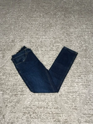 Dondup George  - Hej jag säljer ett par Dondup George. Jeansen i riktigt snygg marinblå färg perfekt för dig som vill ha ett par kvalitetsjeans med grym passform. Nypris ≈4000kr, mitt pris 899kr.  Skick: 9/10 Storlek: W33 Midja: 40cm Lår: 26cm Ytterlängd: 101cm Innerlängd: 78cm  Skriv gärna om du vill ha fler bilder eller har frågor!