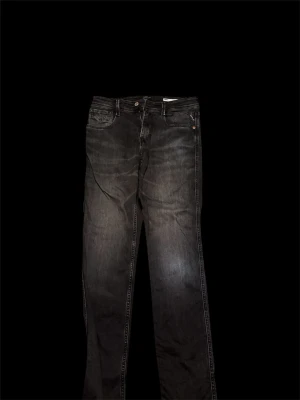 Replay svarta jeans, straight fit - Svarta jeans från Replay med klassisk femficksdesign och raka ben. Jeansen har subtila slitningar och kontrastsömmar, samt Replay-logga på bakfickan. Materialet är robust denim som ger en cool vibe. Passar dig som gillar enkel och stilren look.