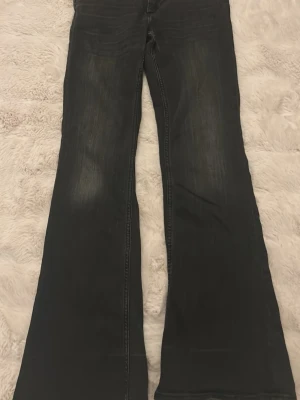 Bootcut jeans från Cheap Monday - Svarta bootcut jeans från Cheap Monday med coolt vitt patch med döskalle på bakfickan. Jeansen har klassisk femficksdesign, knappgylf och är tillverkade i jeansmaterial med lätt tvättad look. Perfekt för dig som gillar retrovibbar och breda ben.