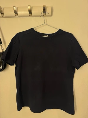 T-shirt Zara - Basic marinblå t-shirt från Zara. Tröjan är i normal längd men lutar sig mot ”kortare” längd. Den har fläck från stryckjärnet, men går bort i tvätt. 