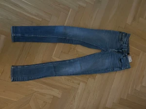 Tiger of sweden jeans blå - Säljer ett par Levi's 511 skinny jeans i klassisk blå tvätt med snygga slitningar. Jeansen har fem fickor, smal passform och normal midja. Materialet är mjukt och stretchigt jeans, perfekt för dig som gillar en tajt look. Levi's patch bak på linningen.