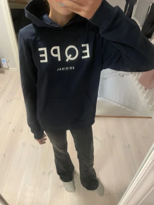 Mörkblå hoodie från EQPE - Säljer en mörkblå hoodie från EQPE(skidmärke) med vit logga framtill. Tröjan har huva, stor magficka och långa ärmar. Unisex 