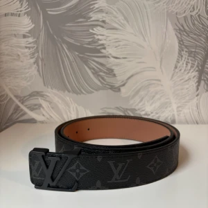 Svart bälte med svart logga - Fin helt ny svart bälte med svart logga. 115cm lång. Med bältet så får man med ett liter metall verktyg man kan göra hål med hjälp av hammare. Tveka inte att dm:a vid frågor eller intresse!