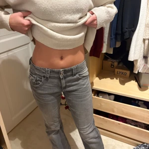 Grå bootcut jeans med låg midja - Säljer ett par grå jeans med snygg bootcut och låg midja. Jeansen har klassiska fem fickor och en cool tvättad look. Perfekta för dig som gillar en avslappnad men trendig stil. Aldrig använt 