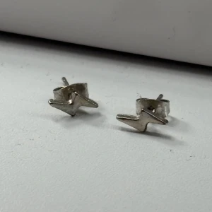 Silvriga blixtformade örhängen - Säljer ett silver par små, coola örhängen i form av blixtar. Använda då gånger! Rengjorda innan det postats! ❣️