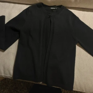 Svart kofta  - Stickad svart kofta med en knapp, från Gina Tricot.  