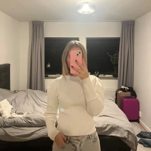 Vit ribbad stickad tröja - Säljer en stilren vit stickad tröja med ribbad struktur. Tröjan har lång ärm och en klassisk rund halsringning. Perfekt för dig som gillar en enkel men snygg look. Passar till både jeans och kjol.