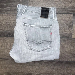 Replay Anbass Jeans  - Snygga ljusgrå Replay Anbass jeans med klassisk femficksdesign och svarta detaljer på bakfickan. Jeansen har smal passform och raka ben, tillverkade i mjukt denimtyg. Perfekta för dig som gillar en stilren och modern look. Midja 47cm, längd 103cm. JAG SKICKAR INGA FLER BILDER NÄR JAG BÄR JEANSEN :) s2 