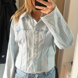 Ljusblå figursydd jeansjacka - Snygg ljusblå figursydd jeansjacka i bra skick. Storlek L men passar även storlek M.