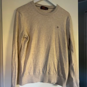 Beige stickad tröja från Morris - Snygg beige stickad tröja från Morris med rund hals och diskret logga broderad på bröstet.  Som ny, använd max 5 ggr