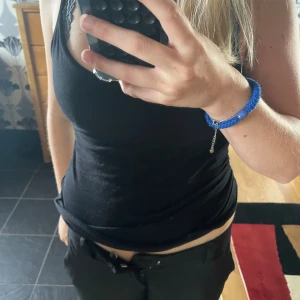 Svarta lågmidjade kostymbyxor - Snygga svarta kostymbyxor med låg midja och klassisk rak passform. Byxorna stängs med dragkedja och knapp framtill. 