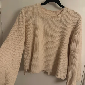 Beige stickad tröja Part Two M - Säljer en beige stickad tröja från Part Two i storlek M. Tröjan har en rund halsringning och långa ärmar med lätt utsvängd form. Grovstickad struktur som ger en chill och mysig vibe. Perfekt under höst och vinter.