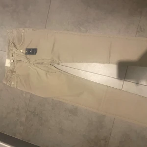 Beige chinos från Hansen & Jacob - Snygga beige chinos från Hansen & Jacob med klassisk femficksdesign och diskreta detaljer. Byxorna har normal passform, raka ben och är tillverkade i mjuk bomull. Perfekta för dig som gillar stilrena och enkla byxor med modern touch.