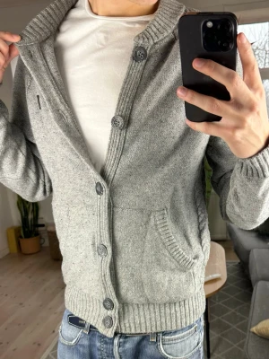 Grå cardigan  - Trendig och varm perfekt nu i vinter. Bra skick. Skriv vid fundering (lite nopprig) mått: A:50cm B:49cm C:42cm D:61cm😊