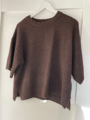 Stickad tröja  - Stickad tröja i skönt material med halvkorta ärmar. 