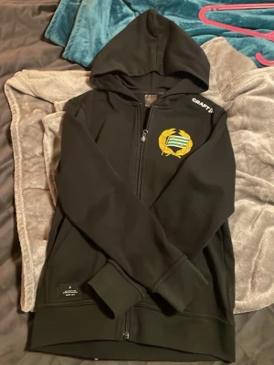 Hammarby zip - En svart Hammarby zip hoodie med märke Craft och storlek 146-152 perfekt till alla tillfällen att ha på sig.