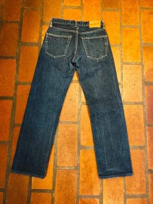 Blue Way Japan selvedge jeans - Säljer ett par klassiska mörkblå jeans från Blue Way Japan med snygg selvedge-detalj vid benslutet. Jeansen har raka ben, fem fickor och kontrastsömmar. Märkespatch i läder baktill. Perfekt för dig som gillar japansk denim och stilrena detaljer.