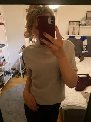 Beige stickad topp från Chelsea - Säljer en stilren beige stickad topp från Chelsea. Toppen har en enkel och klassisk design med rund hals och halvlånga ärmar. Perfekt att matcha med jeans eller kjol för en clean look.