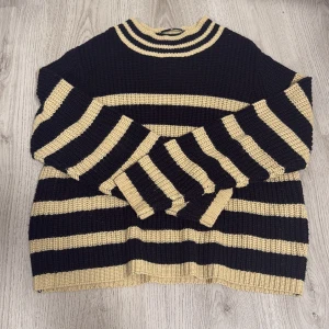 Randig stickad tröja från JDY XL - Säljer en oversized stickad tröja från JDY i storlek XL. Tröjan har breda svarta och beige ränder, rund hals och långa ärmar. Perfekt för dig som gillar en loose fit och vill ha en mysig och cool look med tydliga kontraster.