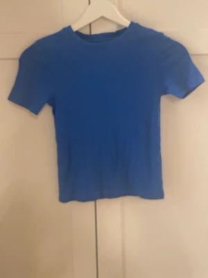 Blå t-shirt från Newyorker XS - Säljer en enkel blå t-shirt från New Yorker i storlek XS. mjukt material som känns skönt mot huden. Säljer eftersom den är knappast använd.