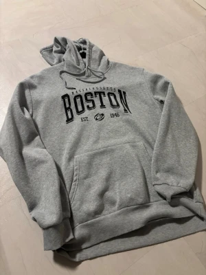 Boston hoodie  - En grå hoodie med Boston, MA tryck. Storlek Large men kan också funka som en lite oversized medium, 