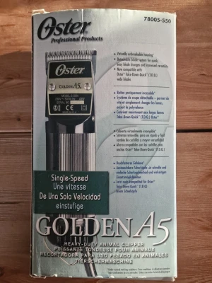 Oster Golden A5 Heavy-Duty Animal Clipper - Oster Golden A5 är en robust djurtrimmer med utbytbara skär, 45W motor och enkel hastighet. Inkluderar två Cryotech-skär (7F, 10), smörjmedel och originalkartong. Perfekt för professionell pälsvård. Synligt i gott skick, komplett med tillbehör.
