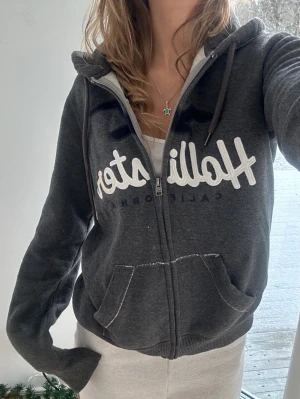 Hollister zip - En zip från Hollister i storlek XS, kan upplevas större i storlek, likt en S (UNISEX). Finns en fläck på loggan men går nog bort i tvätt eller med vanish. Jag fraktar inom 24h. Se liknande plagg i min profil!