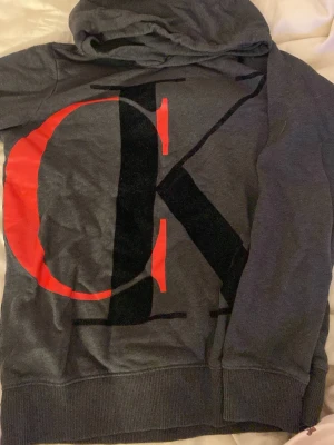 Calvin Klein - Storlek 16/S. Stor logga framtill fint skick. Mörkgrå färg. 