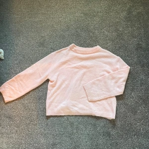 Ljusrosa stickad tröja från KappAhl - Mysig ljusrosa stickad tröja från KappAhl med rund hals och ribbade muddar. Jättefin tröja som passar till mycket! 
