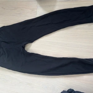 Svarta mjukisbyxor från H&M - Svarta mjukisbyxor från H&M med regular fit och dragsko i midjan. Byxorna har en enkel och clean look, perfekta för chill dagar. Tillverkade i mjukt bomullsmaterial som känns skönt mot huden.