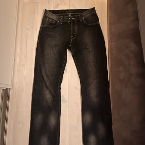 Unika Svarta jeans från Nudie Jeans Co - Snygga svarta jeans från Nudie Jeans Co med klassisk femficksdesign och kontrastsömmar. Jeansen har raka ben och är tillverkade i slitstarkt bomullsdenim. Perfekta för dig som gillar en stilren och tidlös look. Dessa är mycket unika och sällsynta. Till ett mycket bra pris !!