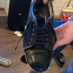 Svarta sneakers med snörning - Svarta sneakers med snörning och rund tå. Ovandel i textil och syntet, med detaljer i vitt längs sömmarna. Skon har en platt sula och klassisk sneakerform. Perfekt för dig som gillar en enkel och stilren look.