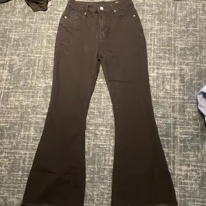 Svarta bootcut byxor från Shein - Svarta bootcut byxor från Shein med klassisk femficksdesign och hög midja. Byxorna är tillverkade i en mix av bomull, polyester och elastan för en bekväm och stretchig passform. Perfekta för dig som gillar en snygg siluett med utsvängda ben.