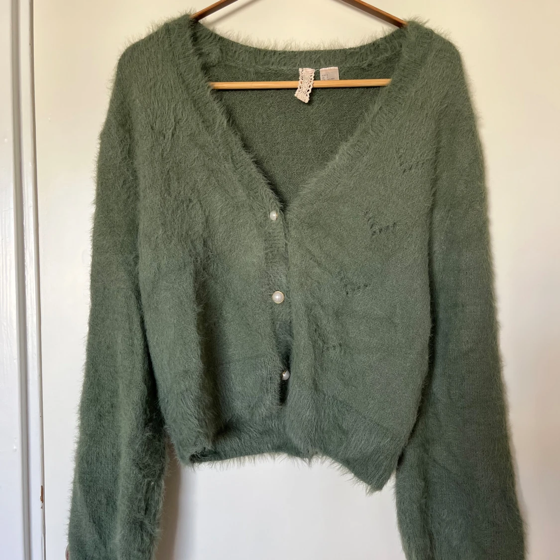 Grön fluffig kofta med pärlknappar