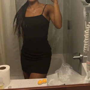 Svart kort klänning med smala axelband - Säljer en svart, tight kortklänning med smala axelband och enkel design. Klänningen har en figurnära passform och är perfekt för dig som gillar en stilren look. Passar dig som vill ha något klassiskt och enkelt.