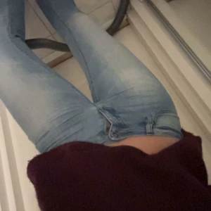 Low waist Ljusblå jeans från ONLY, W26 L34 - Snygga low waist ljusblå jeans från ONLY, storlek W26 Tillverkade i mjukt denimtyg med dragkedja och knapp framtill. Har klippt jeansen så att det passar ca 160cm lång Person. Aldrig använt sen jag köpte! 