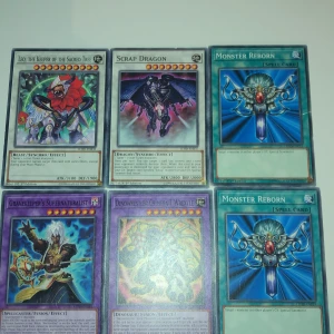 Yu-Gi-Oh! Kortpaket (6 kort) - Samling med 6 Yu-Gi-Oh! kort, inklusive Monster Reborn, Scrap Dragon, Leo the Keeper of the Sacred Tree, Gravekeeper's Supernaturalist och Dinowrestler Chimera T Wrextle. Perfekt för dig som vill boosta din lek med kraftfulla och ikoniska kort. Passar både samlare och duellanter!