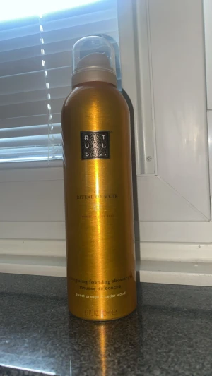 Rituals Ritual of Mehr duschmousse - Rituals Ritual of Mehr energising foaming shower gel med doft av söt apelsin och cederträ. Flaskan är metallic orange med svart logga och har en praktisk plastkork. Perfekt för att ge huden en fräsch och uppiggande känsla.