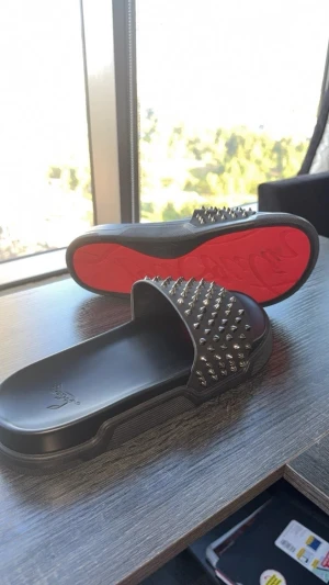 Christian Louboutin svarta sandaler bytes - Svarta sandaler från Christian Louboutin med ikonisk röd sula och coola silverfärgade nitar över remmen. Tillverkade i syntetmaterial med platt sula och öppen tå. Bytes mot förslag 👌